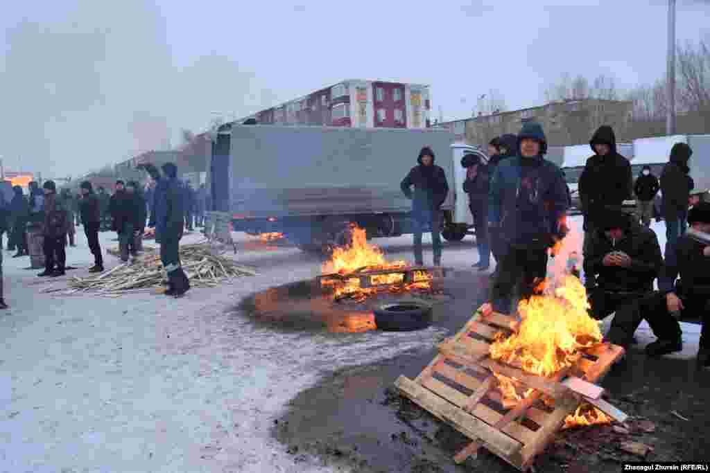 Суық күні алаңда от жағып жылынып отырған демонстранттар.&nbsp;Ақтөбе, 6 қаңтар 2022 ж.