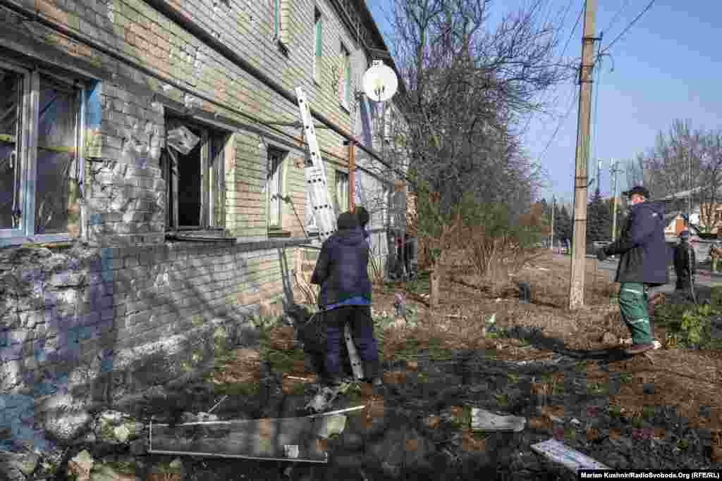 Робітники приїхали на заміну вікон, розбитих артилерійським снарядом в Новолуганському. Місто розташоване неподалік від лінії розмежування, що відокремлює позиції ЗСУ від російських гібридних військ